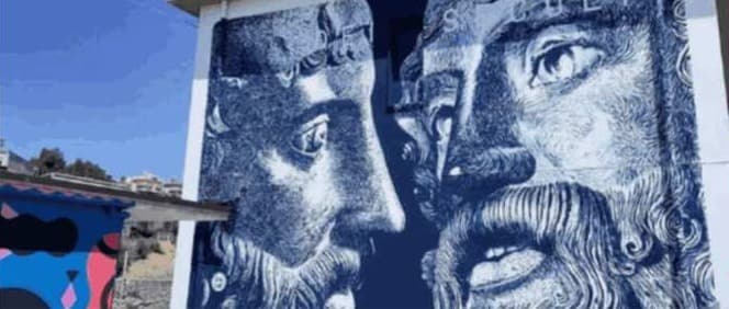 Il murale dei Bronzi che accoglie chi arriva alla stazione di Riace